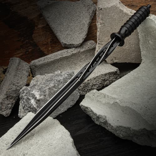 The Titanium Spiral Dagger laying on broken cinder blocks.